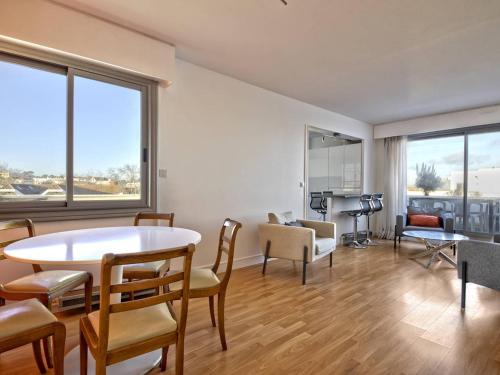 un salon avec une table et des chaises dans l'établissement Arcachon T2, Terrasse, Parking, à 240m de la Plage! - FR-1-433-114, à Arcachon