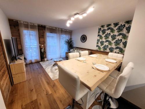 une salle à manger avec une table et des chaises blanches dans l'établissement Appartement neuf 32 m² au centre des Gets, pour 4 personnes, proche des commerces et pistes de ski - FR-1-598-160, aux Gets