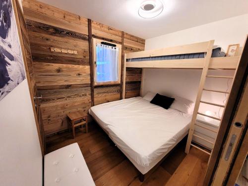 Cette petite chambre dispose de lits superposés et d'une échelle. dans l'établissement Appartement neuf 32 m² au centre des Gets, pour 4 personnes, proche des commerces et pistes de ski - FR-1-598-160, aux Gets