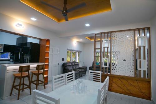 a living room with a white table and chairs at Serene Retreat in Cochin