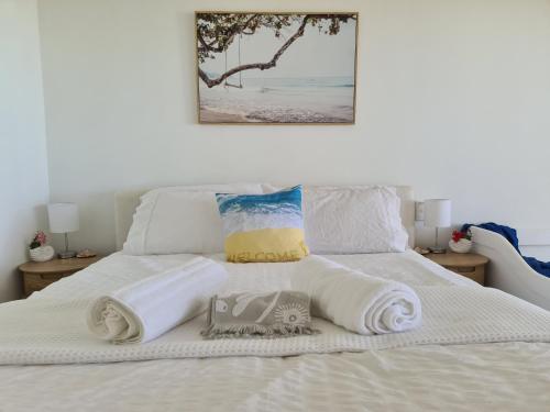 1 dormitorio con 1 cama con toallas en Dolphin Heads - Resort Unit - Absolute Beachfront! - Whitsunday Getaway! en Mackay
