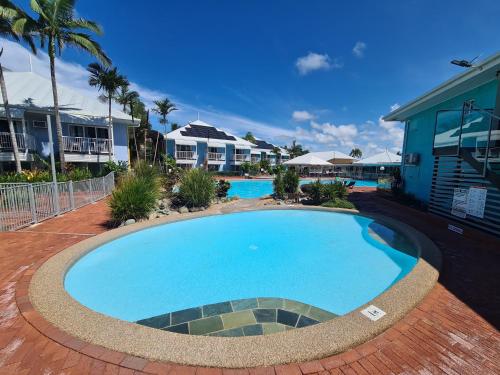 a large blue swimming pool in front of some houses at Dolphin Heads - Resort Unit - Absolute Beachfront! - Whitsunday Getaway! in Mackay