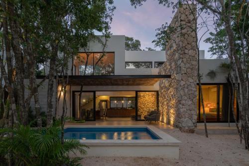 an exterior view of a house with a swimming pool at Twelve O'Clock - Luxury Villas in Tulum