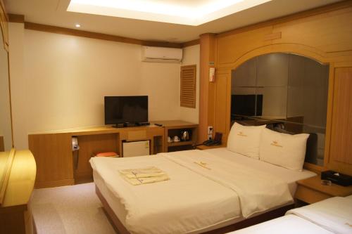 a hotel room with a bed and a flat screen tv at Princess Hotel in Seoul