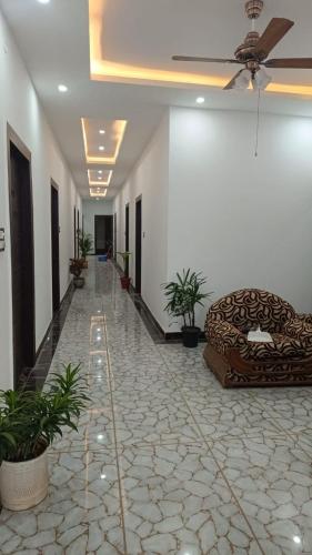 un couloir avec un canapé dans une pièce ornée de plantes dans l'établissement Yash Guest house, à Pīrthala