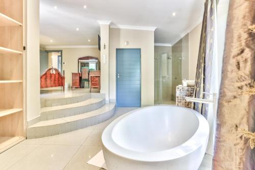 Habitación con baño con bañera blanca grande. en Villa Jesdene, en Ciudad del Cabo