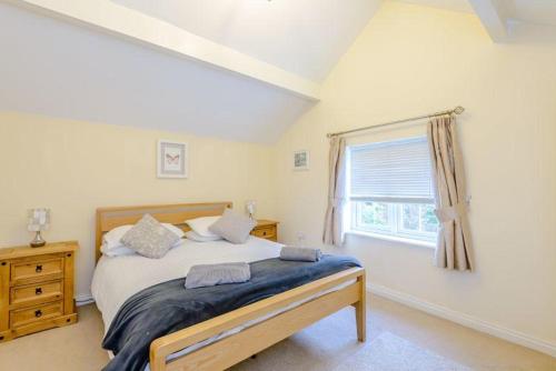 Un dormitorio con una cama grande y una ventana en Tarporley Holiday Cottage en Tarporley
