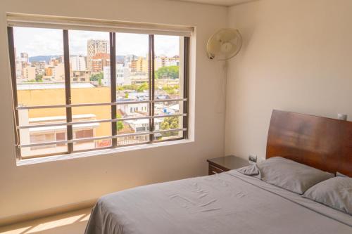 a bedroom with a bed and a large window at Apt Bedroom Apartment era With Doorman in Bucaramanga