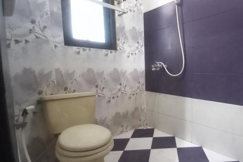 uma casa de banho com um WC e uma janela em RedDoorz Syariah near Bypass Krian em Gabung
