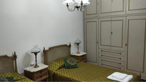 a bedroom with two beds and a chandelier at Plaza Libertad in Santiago del Estero