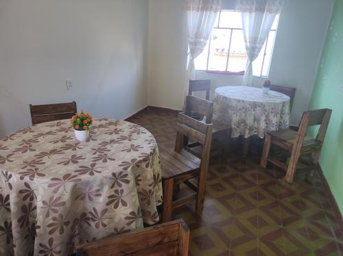 a dining room with two tables and chairs and a table with flowers at HOTEL AMERICA in Tarija