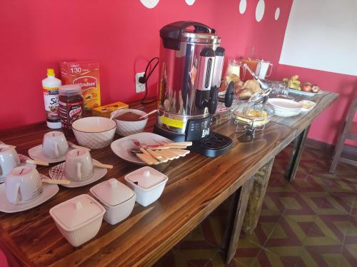 una mesa de madera cubierta con platos y una batidora en HOTEL AMERICA en Tarija