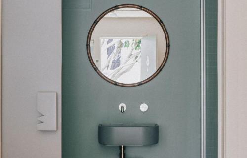 um espelho por cima de um WC numa casa de banho em The Cheshire Cat Motel em Gold Coast