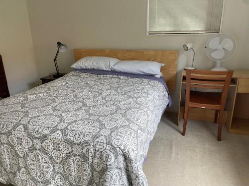 a bedroom with a bed and a desk and a chair at Rooms in Epsom House in Auckland