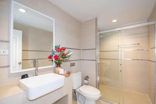 a bathroom with a toilet and a sink and a shower at November T Pool Villa 1, 4Beds Thai- Bali Jomtien Beach in Jomtien Beach