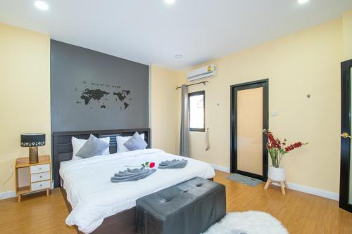 um quarto com uma cama grande com lençóis brancos e uma janela em November T Pool Villa 1, 4Beds Thai- Bali Jomtien Beach em Praia de Jomtien