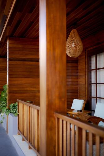 a room with a porch with a desk and a laptop at Fourteen Roses Boutique Hotel, Kuta in Legian