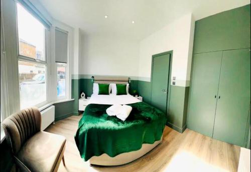 ロンドンにあるEn-suite Room look like hotelの緑と白のベッドルーム(ベッド1台、椅子付)