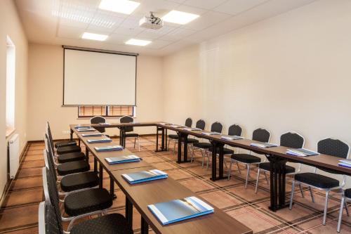 a conference room with tables and chairs and a whiteboard at Mikołajki Resort Hotel & Spa Jora Wielka in Mikołajki
