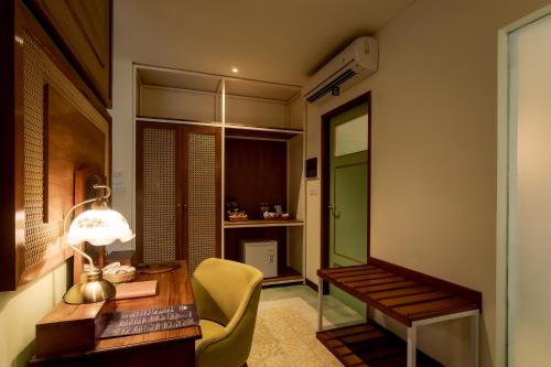 a room with a desk with a lamp and a chair at Fourteen Roses Boutique Hotel, Kuta in Legian