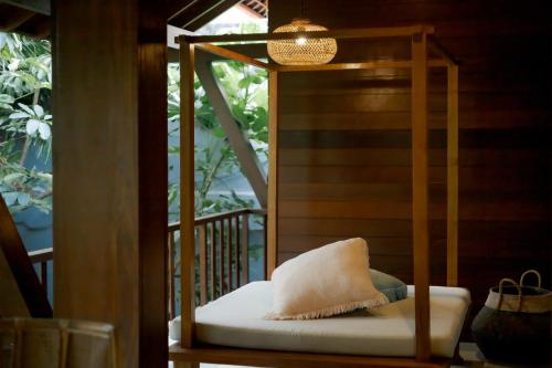 a chair with a pillow on a porch at Fourteen Roses Boutique Hotel, Kuta in Legian