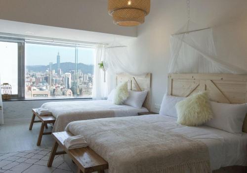 2 camas en una habitación con ventana grande en 所在行旅-渡咕所在UrbanAbode DUGU en Taipéi