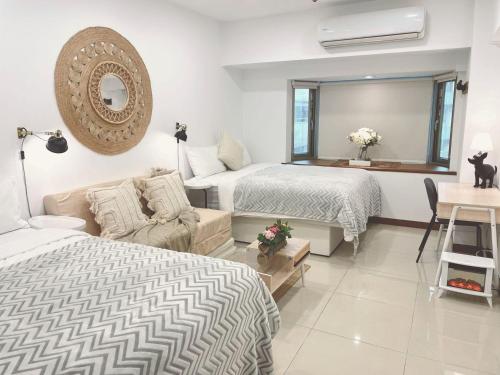 a bedroom with two beds and a couch and a mirror at 所在行旅2館-渡咕所在 UrbanAbode2-DUGU in Taipei