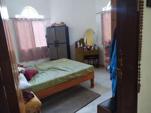 a bedroom with a bed and a dresser and a mirror at Banaga Residence in Talibon