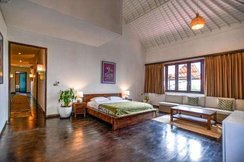 a bedroom with a bed and a living room at Melo Suites Hotel in Seminyak