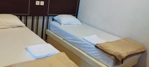 a pair of beds in a small room at Luna Guest House in Tanjungkarang-Telukbetung