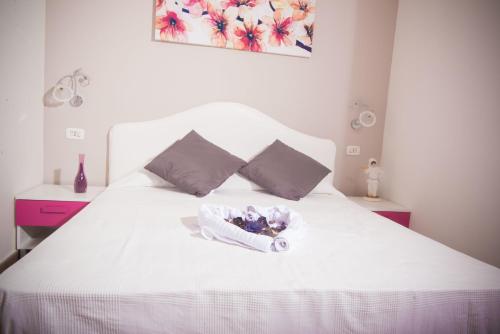 ナポリにあるB&B Lungomareの白いベッド(花のバスケット付)