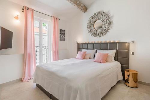 - une chambre avec un grand lit, des oreillers roses et un miroir dans l'établissement Facing d Port of Cannes Duplex with a view, à Cannes