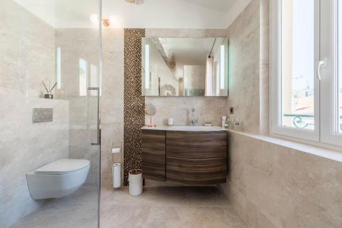une salle de bain avec un lavabo, des toilettes et un miroir dans l'établissement Facing d Port of Cannes Duplex with a view, à Cannes