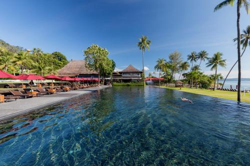 a pool at a resort with people swimming in it at The Vijitt Resort Phuket - SHA Extra Plus in Rawai Beach