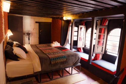 um quarto com uma cama num quarto com janelas em Hira Guest House em Patan