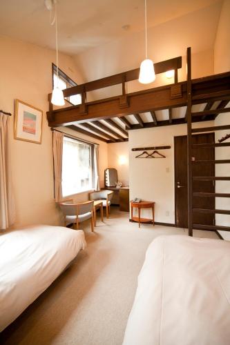 a bedroom with two beds and a loft at Poetical in Matsumoto