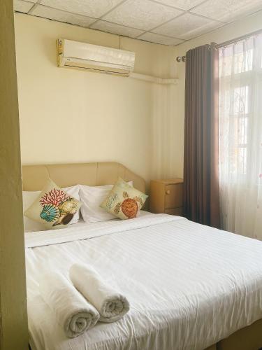um quarto com uma cama branca e toalhas em ห้องพักโอบอ้อมอารีย์ Orb Aom Aree em Hua Hin