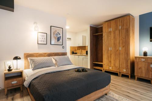 a bedroom with a large bed and a kitchen at ORSO Rooms & Apartments - LoftAffair Collection in Warsaw