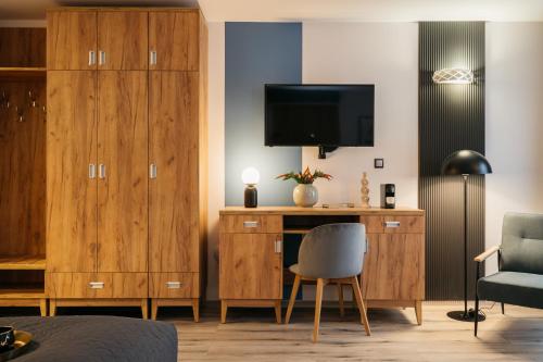 a bedroom with a desk with a tv and a chair at ORSO Rooms & Apartments - LoftAffair Collection in Warsaw