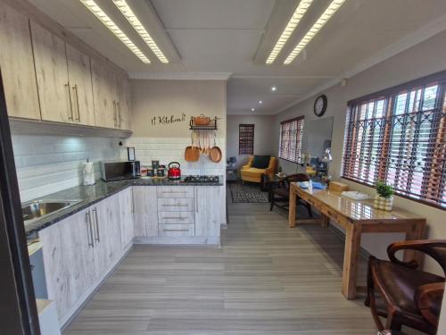 - une cuisine avec des placards blancs et une table dans une pièce dans l'établissement Le-n-Biki Air B&B, à Harrismith