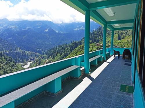 a balcony with benches and a view of mountains at Aman Resort, Tosh Village, Himachal Pradesh in Tosh