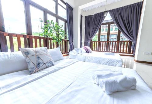 1 dormitorio con 2 camas y balcón con ventanas en Collection O 90858 Bentong Wellness Homestay Midland, en Kampong Sungai Chendarawi