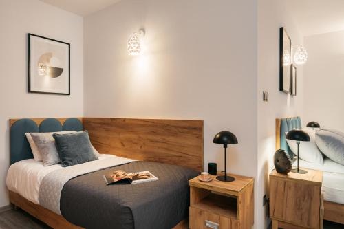 a bedroom with a bed with a wooden headboard at ORSO Rooms & Apartments - LoftAffair Collection in Warsaw