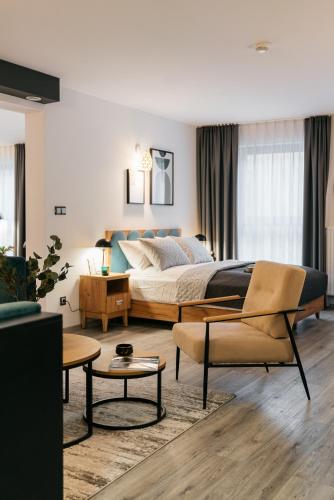 a bedroom with a bed and a couch and a table at ORSO Rooms & Apartments - LoftAffair Collection in Warsaw