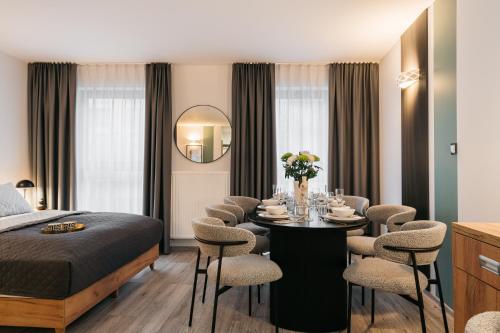 a bedroom with a bed and a table with chairs at ORSO Rooms & Apartments - LoftAffair Collection in Warsaw