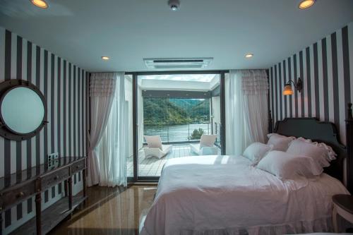 um quarto com uma cama grande e uma varanda em SS Resort em Gapyeong