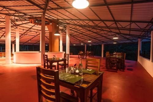 a dining room with tables and chairs in a building at Makayiram Retreat in Munnar