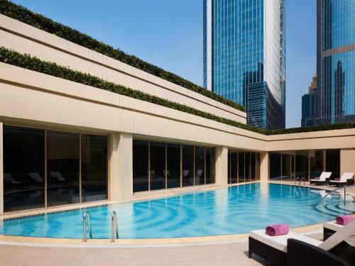 a large swimming pool in a building with tall buildings at The Portman Ritz-Carlton Shanghai in Shanghai