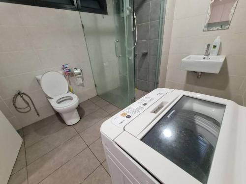 a bathroom with a shower and a toilet and a sink at AZ Apartment @ Cyberjaya Netflix Wi-Fi in Cyberjaya