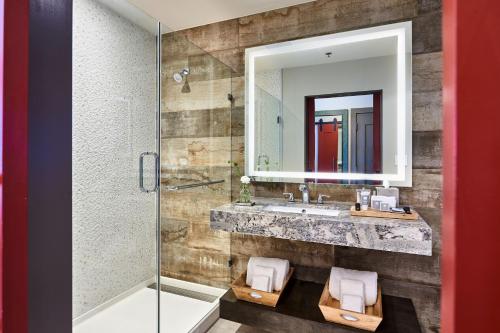 a bathroom with a sink and a mirror at The Stella Hotel, Autograph Collection in Bryan